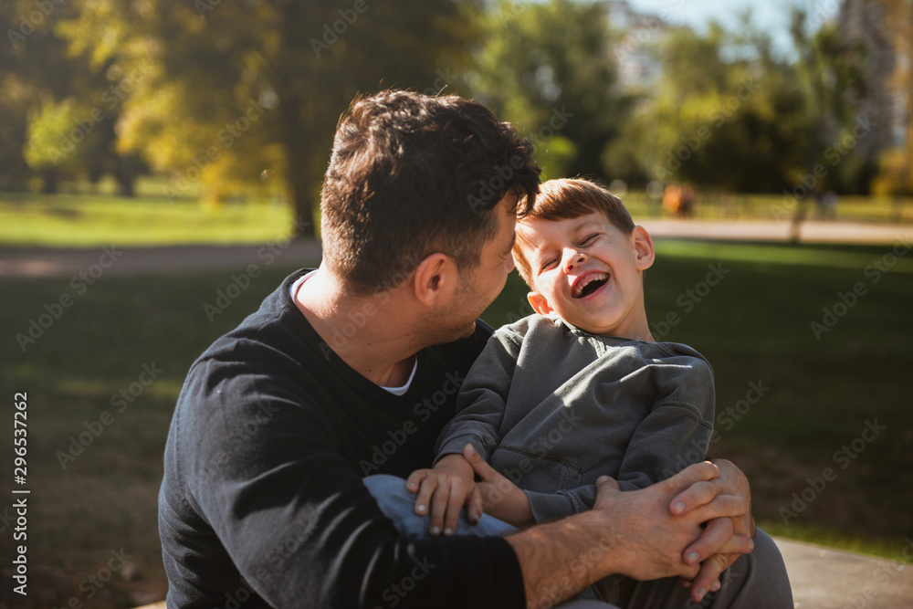 Father and son sitting on a skate ramp and having fun Father and son sitting on a skate ramp and having fun