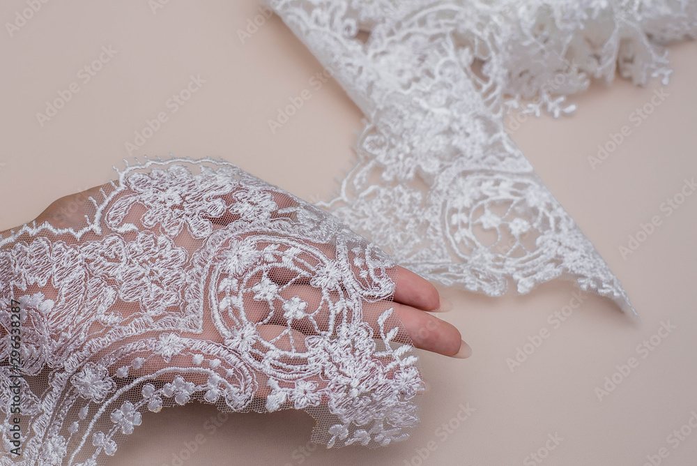 Texture lace fabric. lace on white background studio. thin fabric made of yarn or thread. a background image of ivory-colored lace cloth. White lace on beige background. Texture lace fabric. lace on white background studio. thin fabric made of yarn or thread. a background image of ivory-colored lace cloth. White lace on beige background.