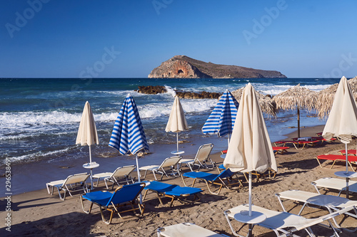 umbrellas and sunbeds on the beach on the island of Crete, Greece. © GKor