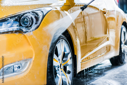 Car wash using high pressure water. Detail of manual wheel cleaning concept. © Milan