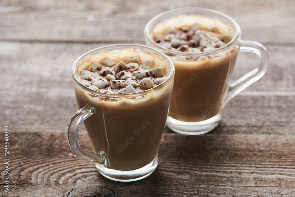 cacao with marshmallow and cacao powder in mugs on wooden table cacao with marshmallow and cacao powder in mugs on wooden table