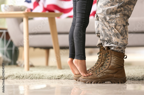 Girl standing on feet of he...