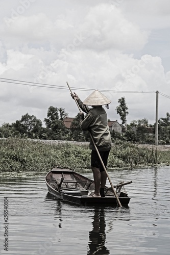 Ninh Binh, Vietnam »; August 2017: Local fisherman rowing on his back in the canals of Ninh Binh, black and white retouching