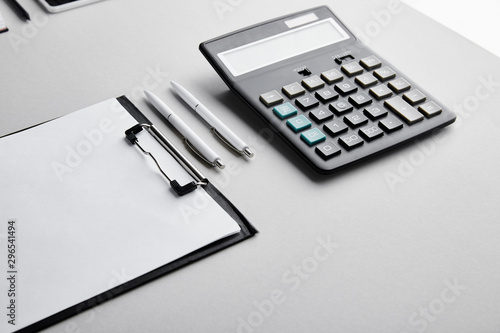 clipboard with copy space, pens and calculator on table