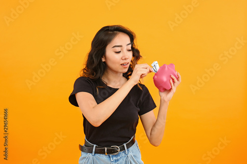 Asian woman putting money i...