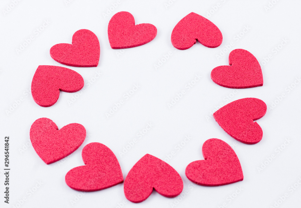 Fototapeta premium Red crafting foam hearts in white background. Decor hearts by cutting from red crafting foam