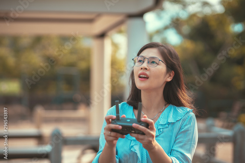 Young happy woman play drone with drone controller on hand