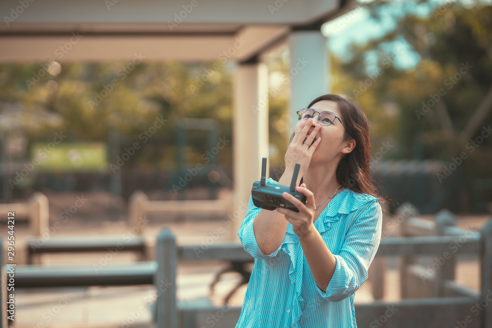 Young happy woman play drone with drone controller on hand Young happy woman play drone with drone controller on hand