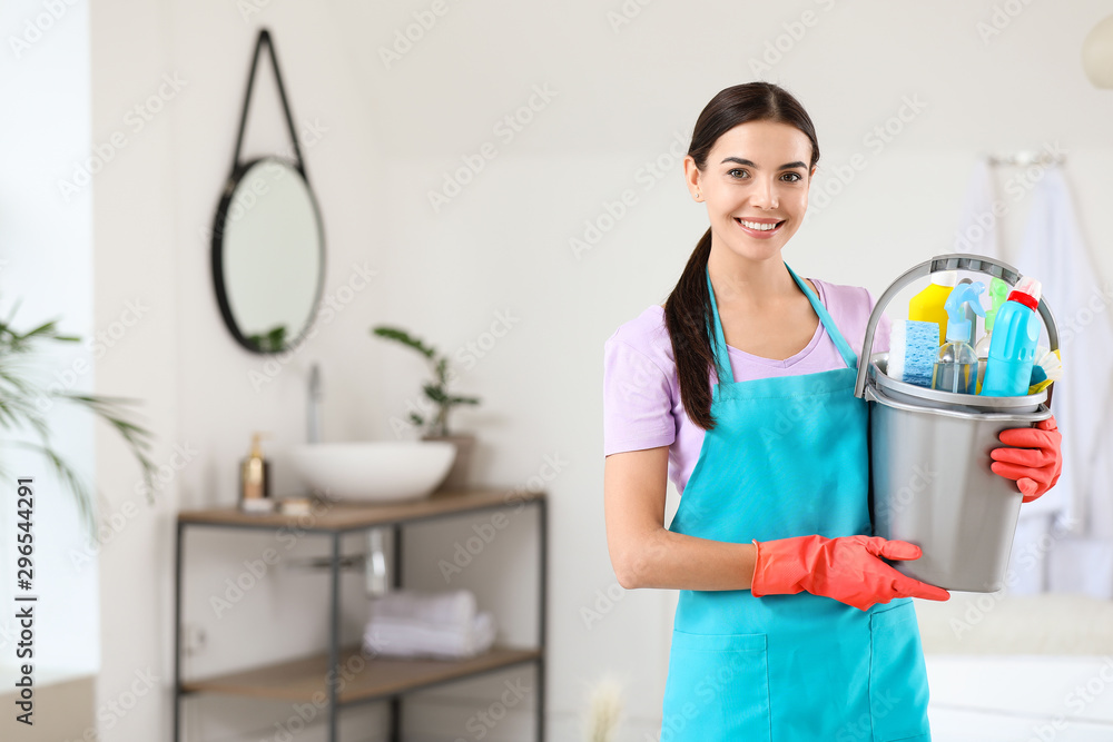 Beautiful young woman with cleaning supplies in bathroom Beautiful young woman with cleaning supplies in bathroom