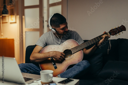 man playing guitar at his home photo