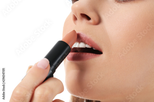 Beautiful young woman applying lipstick against white background, closeup © Pixel-Shot