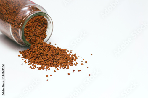 Open glass jar with instant coffee spilled out. White solid background. Isolation on white.  