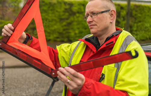 Closeup of a man builds a warning triangle on the street
