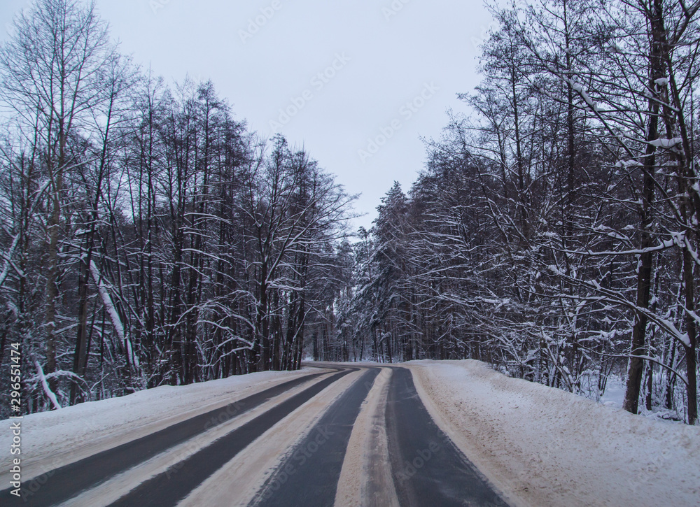 Asphalt road in the forest covered with snow Asphalt road in the forest covered with snow