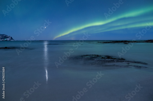 Beautiful northern lights over the snow covered winter landscape of the Lofoten islands