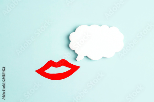 Smiling femalen red lips with speech bubble on a blue background. photo