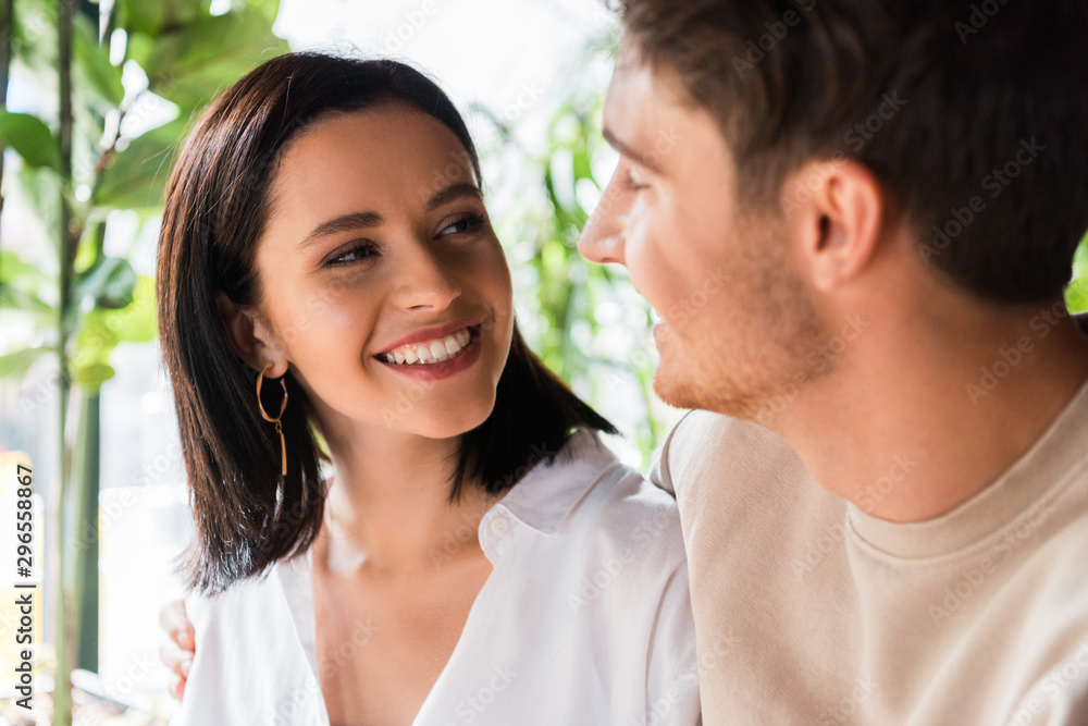 selective focus of happy woman looking at man selective focus of happy woman looking at man