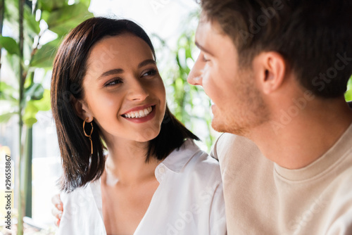selective focus of happy woman looking at man