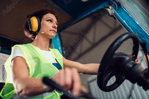 Woman forklift operator driving vehicle photo