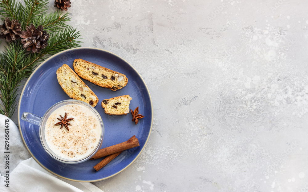 Eggnog. Christmas milk cocktail with cinnamon and anise, served in glass mug with biscotti, winter spices, fir branches and cones. Eggnog. Christmas milk cocktail with cinnamon and anise, served in glass mug with biscotti, winter spices, fir branches and cones.