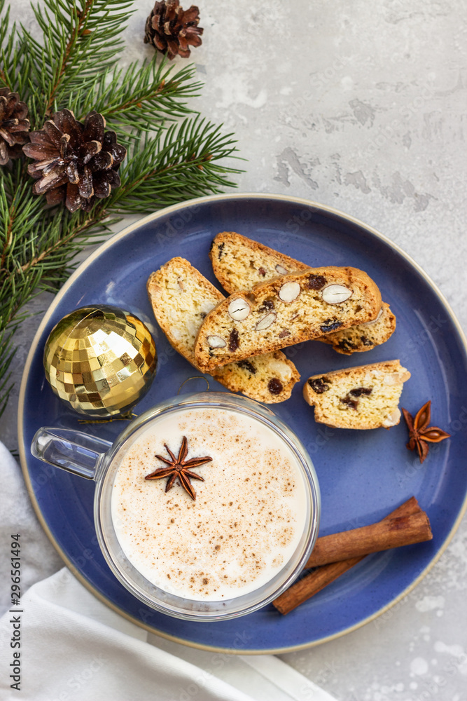 Eggnog. Christmas milk cocktail with cinnamon and anise, served in glass mug with biscotti, winter spices, fir branches and cones. Eggnog. Christmas milk cocktail with cinnamon and anise, served in glass mug with biscotti, winter spices, fir branches and cones.