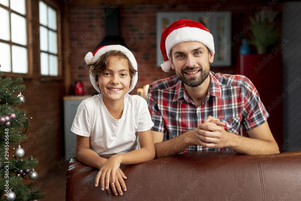 Medium shot boy with father posing together Medium shot boy with father posing together