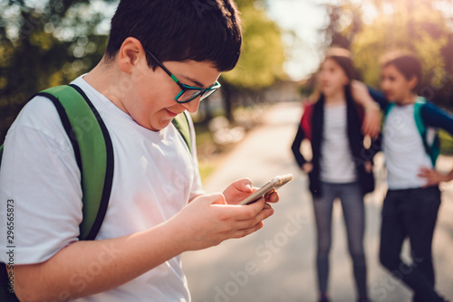 Boy standing at schoolyard cyberbullying