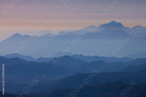 Pastel tones of distant blue mountains, illuminated by the pale pink light of dawn. foggy mountain landscape with soft light -