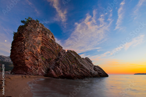 Night landscape, a dark blue nest with stars, a red streak of evening dawn and a huge cloaked cliff by the sea, b