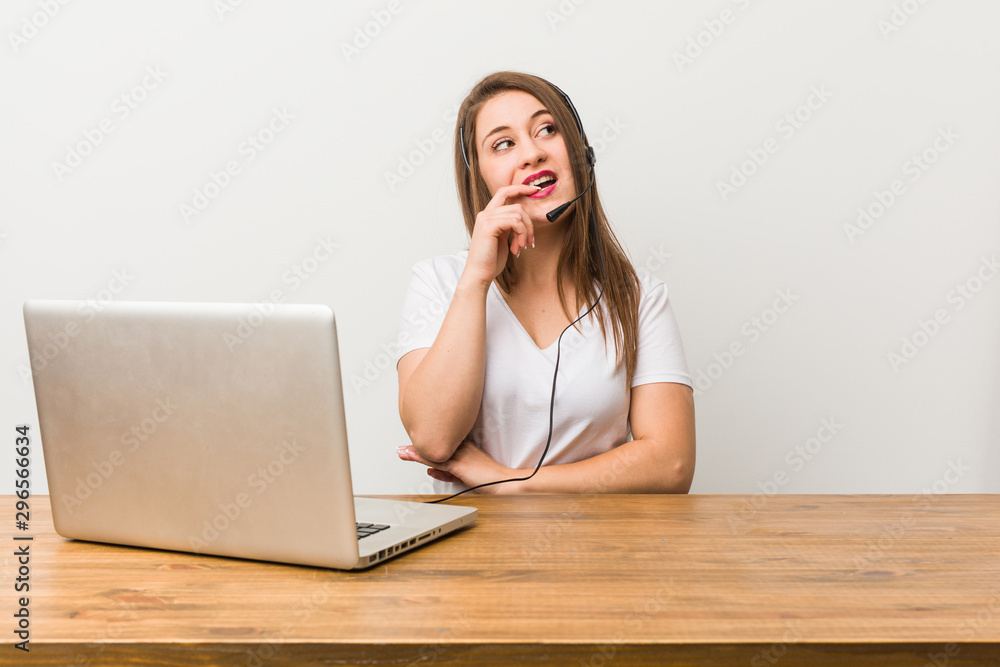 Young telemarketer woman relaxed thinking about something looking at a copy space. Young telemarketer woman relaxed thinking about something looking at a copy space.