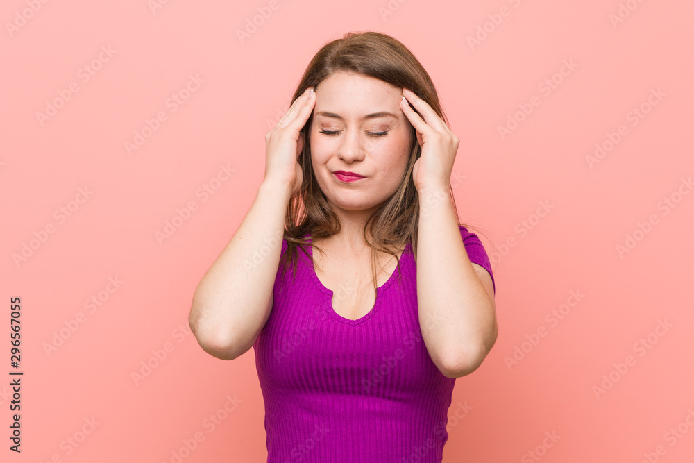 Young hispanic woman against a pink wall touching temples and having headache. Young hispanic woman against a pink wall touching temples and having headache.