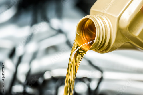 Pour motor oil to car engine. Fresh yellow liquid change with back light. Maintenance or service vehicle concept. photo