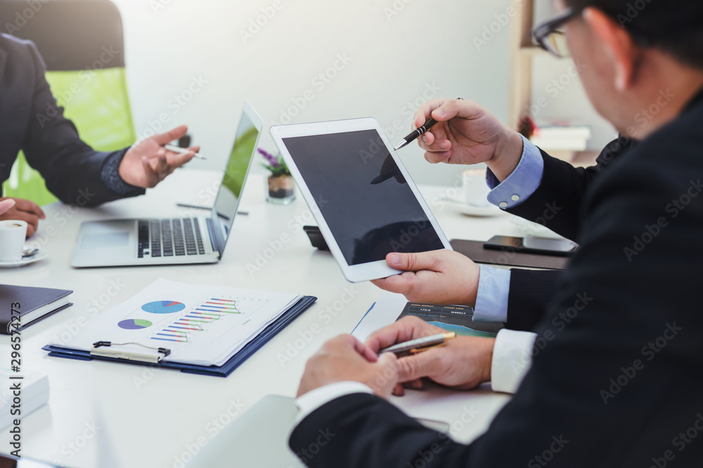 Broker holding pen pointing to graph data to show investors see growth in business investment. Broker holding pen pointing to graph data to show investors see growth in business investment.