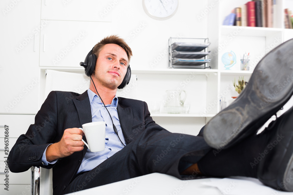 Business man listening to music in office