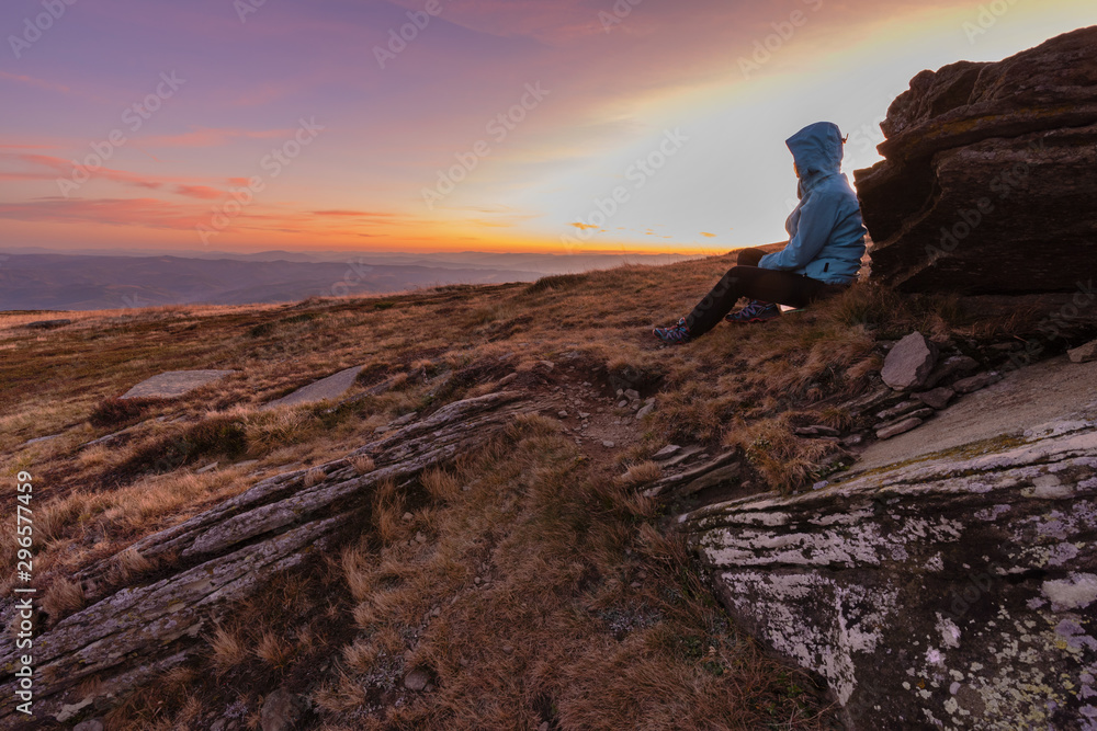 Young girl travels through beautiful mountain ranges with fantastic views of autumn meadows and peaks Young girl travels through beautiful mountain ranges with fantastic views of autumn meadows and peaks
