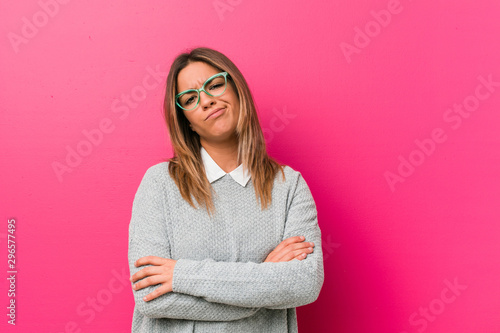 Young authentic charismatic real people woman against a wall unhappy looking in camera with sarcastic expression. photo