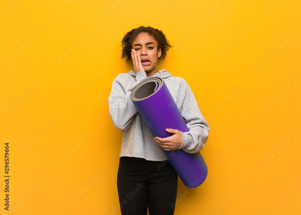 Young fitness black woman desperate and sad. Holding a mat. Young fitness black woman desperate and sad. Holding a mat.