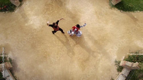 Aerial view from drone of man and woman dancing flamenco in park. Spanish people and traditional dance in Andalusia, Spain. Dancers performing traditional show in park. Couple and music arts photo