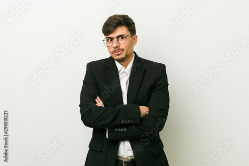 Young business hispanic man unhappy looking in camera with sarcastic expression.