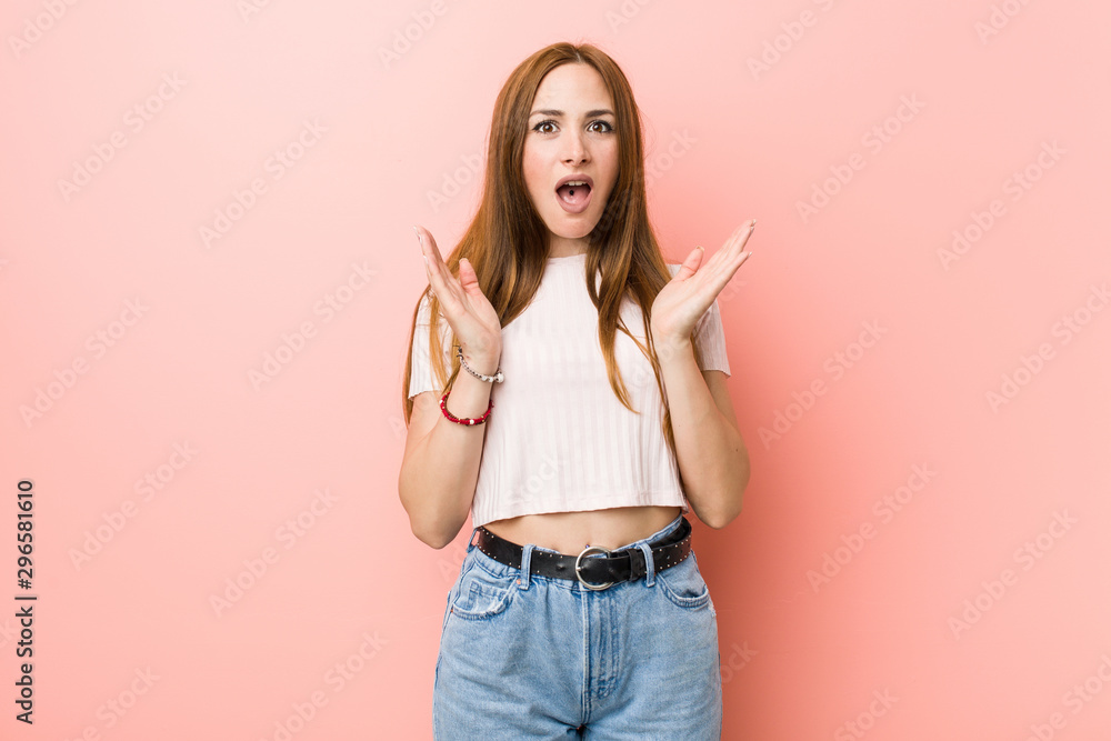 Young redhead ginger woman against a pink wall surprised and shocked. Young redhead ginger woman against a pink wall surprised and shocked.