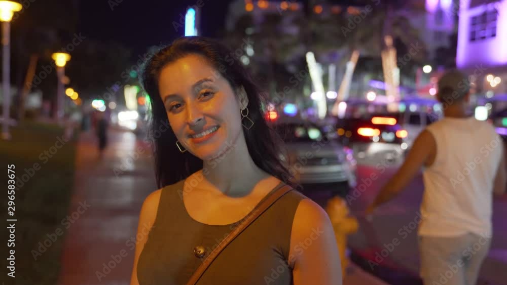 Woman in miami beach night ocean drive looking at camera Woman in miami beach night ocean drive looking at camera