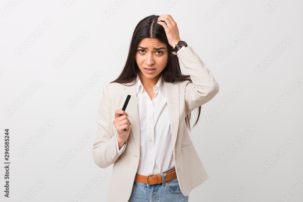 Young arab woman holding a credit card being shocked, she has remembered important meeting. Young arab woman holding a credit card being shocked, she has remembered important meeting.