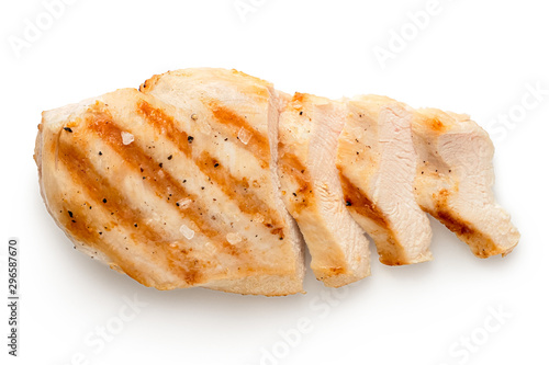 Slika na platnu Partially sliced grilled chicken breast with grill marks, ground black pepper and salt isolated on white