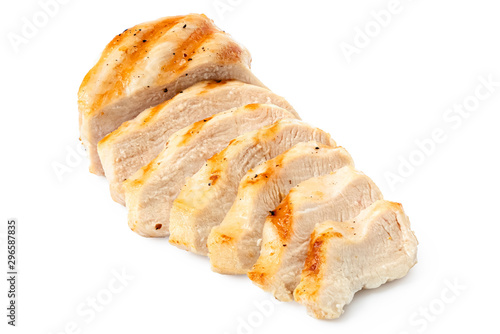 Partially sliced grilled chicken breast with grill marks, ground black pepper and salt isolated on white.