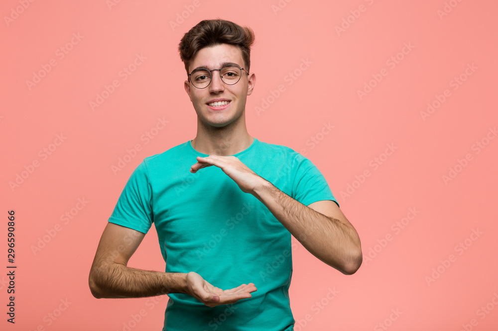 Young cool caucasian man holding something with both hands, product presentation. Young cool caucasian man holding something with both hands, product presentation.