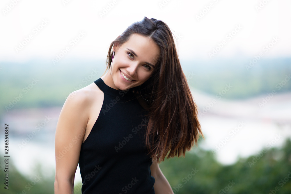 Young pretty likable cheerful woman posing summer city outdoor in Kyiv, Ukraine. Beautiful self-confident girl with long brown hair posing on Dnipro river bank enjoing her life, urban lifestyle Young pretty likable cheerful woman posing summer city outdoor in Kyiv, Ukraine. Beautiful self-confident girl with long brown hair posing on Dnipro river bank enjoing her life, urban lifestyle