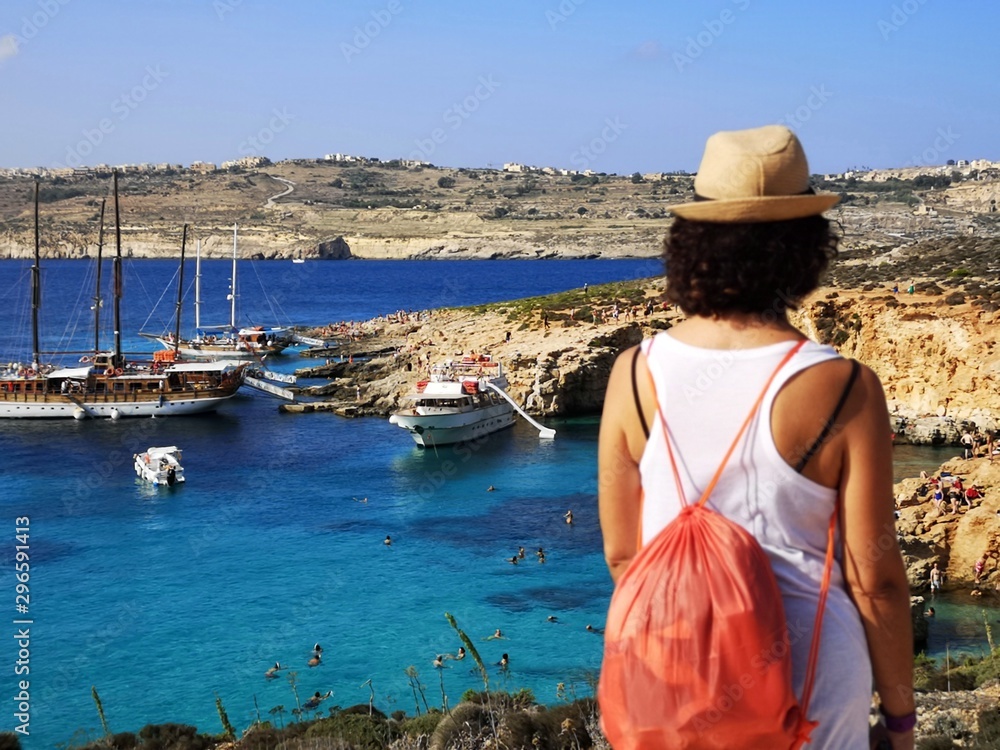 tourist from behind blue lagoon in comino, Malta