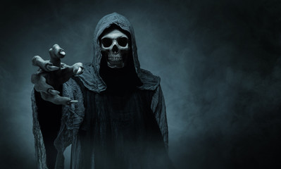 Grim reaper reaching towards the camera over dark background with copy space