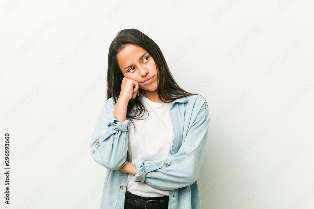Young hispanic woman who feels sad and pensive, looking at copy space. Young hispanic woman who feels sad and pensive, looking at copy space.