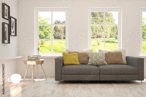 Stylish room in white color with sofa and summer landscape in window. Scandinavian interior design. 3D illustration